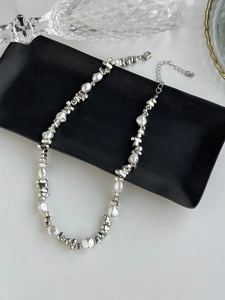 Close-up of silver metal beads and faux pearls necklace with adjustable lobster clasp