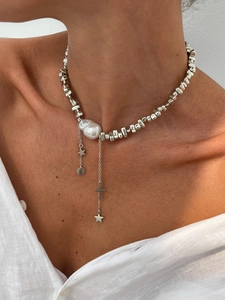 Baroque pearl necklace with silver beads and hanging star and cross pendants on a model