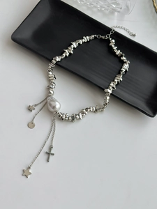 Detailed silver chain necklace with drop pearl, star charms, and crucifix pendant detail