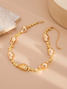 Detail of chunky gold beaded necklace with irregular metallic beads and lobster clasp
