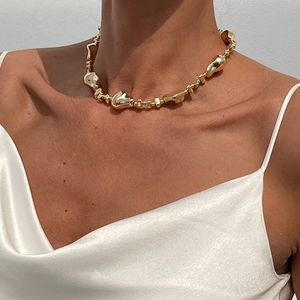Golden irregular lava-shaped metal choker necklace with high-gloss mirror finish on model