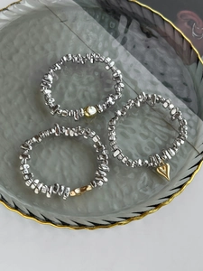 Vue détaillée de trois bracelets perlés élastiques avec breloques cœur argent et or