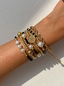 Détails rapprochés de bracelets multicouches dorés avec perles et médaille