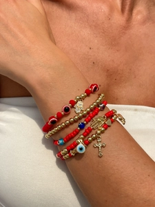 Vue détaillée de bracelets bohèmes en perles rouges et dorées avec breloques hamsa