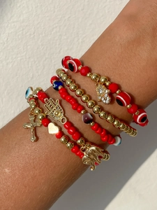 Détail de bracelets en perles avec pendentifs Œil bleu, Croix, Cœur et Main de Fatma