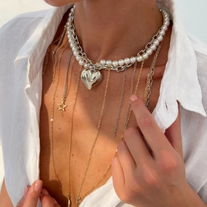 Détail du ras-du-cou en perles avec pendentif cœur et chaîne à breloque étoile