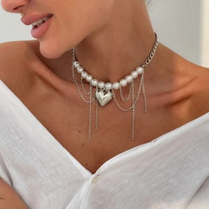 Détail du collier pendentif coeur argenté avec perles et longues franges sur le mannequin