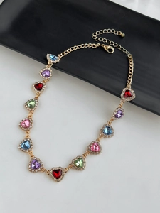 Vue détaillée de pierres colorées en forme de cœur avec cristaux sur collier doré