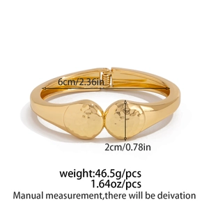 Irregular golden metal bangle with hammer finish details and sizing measurements