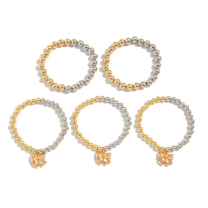 Five-piece stackable beaded bracelet set with gold and silver beads and bow pendants
