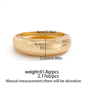 Detail of chunky gold bangle showing twisted texture and dimensions 6cm by 2.5cm