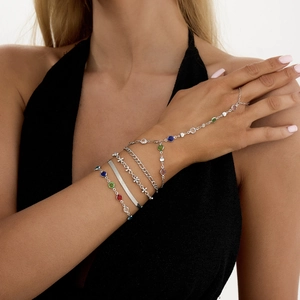 Detailansicht eines mehrlagigen silbernen Ring-Armbands mit lebhaften bunten Edelsteinen