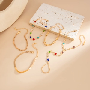 Detailansicht eines 5-teiligen Gold-Schmucksets mit Edelsteinen und Perlen-Ring-Armband