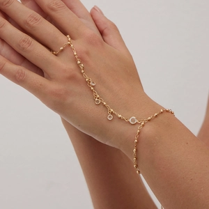 Détail d'un bracelet bague doré avec cristaux clairs et chaîne de main pour femme