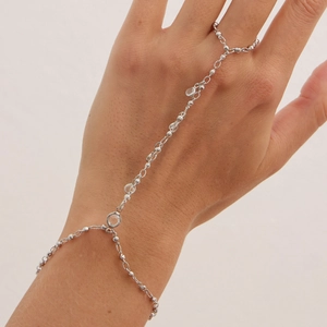 Vue détaillée du bracelet de doigt argenté avec cristal rond et perles métalliques fines