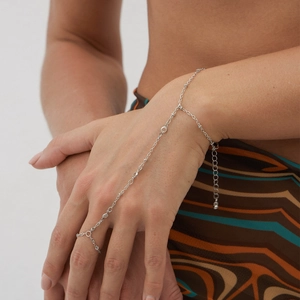 Bracelet bague main en argent avec perles et cristaux, porté par un mannequin avec élégance