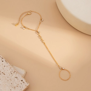 Vue détaillée d'un bracelet de doigt doré avec chaînes réglables et accents en cristal