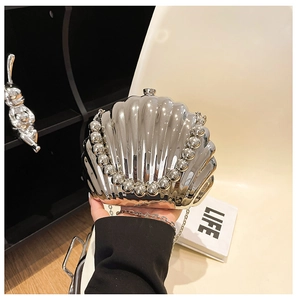 Detail of silver shell evening clutch with bead handle and metallic chain strap