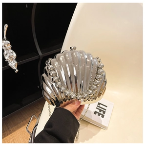 Detailed view of silver shell-shaped evening bag with wave texture and bead trim