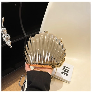 Close-up of golden shell clutch bag with metallic mirror finish and chain strap