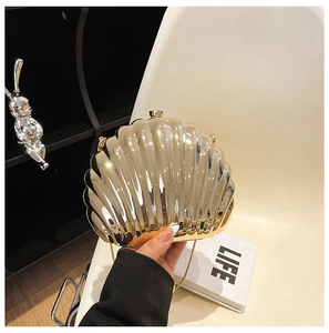 Close-up of golden shell evening clutch with metallic texture and sleek chain strap