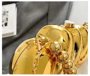 Detailed macro view of the premium shiny gold metallic texture and chain handle of the bag