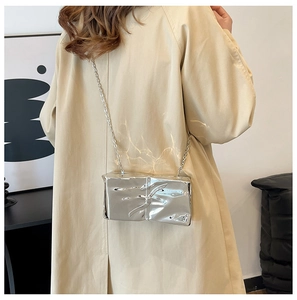 Detail of silver liquid metal texture acrylic evening bag with delicate chain strap