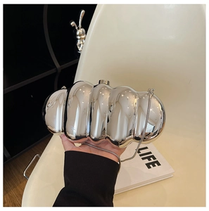 Detail view of silver caterpillar acrylic evening bag with metallic wave pattern surface