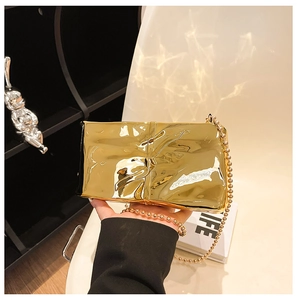 Detail of gold quilted evening clutch with metallic texture and beaded chain strap