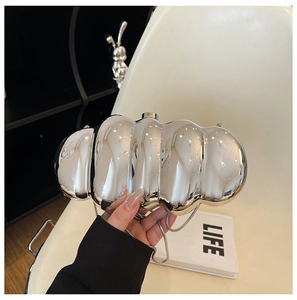 Detail of silver mirror acrylic evening bag with cloud-like pleats and metal chain