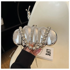 Detail of silver wavy acrylic evening bag with beaded handle and metallic chain