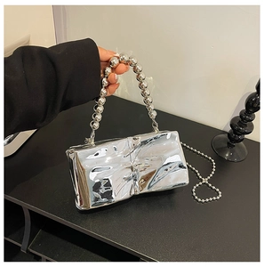 Close-up of metallic silver quilted handbag with oversized round bead handle and chain