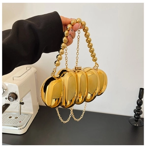 Detail of gold metallic caterpillar evening bag with beaded handle and snap closure