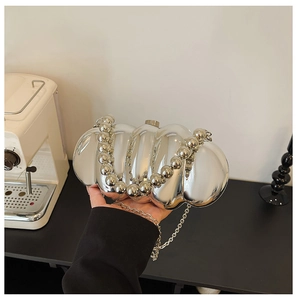 Detail of silver mirror acrylic evening bag with beaded handle and metal chain