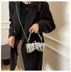 Detailaufnahme der silbernen unregelmäßigen Abendtasche mit Hochglanz-Finish und Perlen