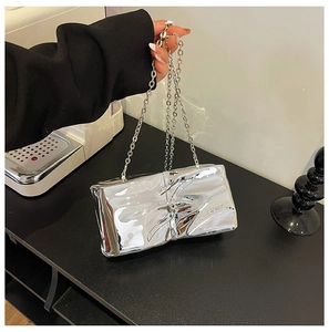 Detailed close-up of metallic silver quilted mini bag with liquid fold texture and chain