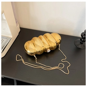 Detailed view of the luxury gold caterpillar acrylic clutch with a metallic snake chain