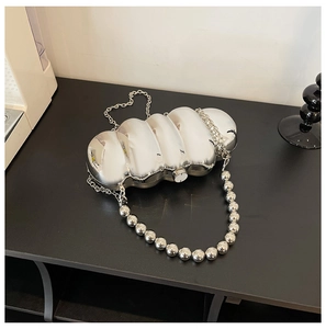 Detail view of silver wave acrylic evening bag with metallic finish and beaded chain handle