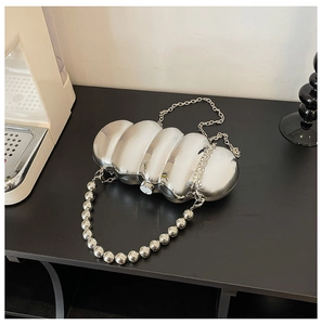Close-up of silver wavy metallic evening bag with large bead handle and chain strap