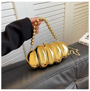 Detailed view of golden acrylic evening clutch with beaded handle and chain strap