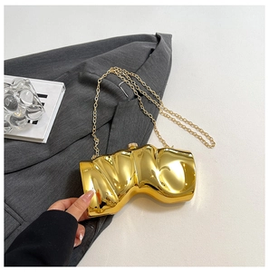 Nahaufnahme der goldenen Fluid-Skulptur Abendtasche mit poliertem Spiegel-Finish auf Anzug