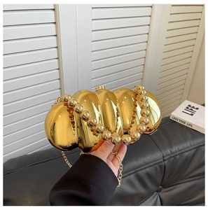 Detail of gold caterpillar acrylic evening bag with scalloped texture and beaded handle