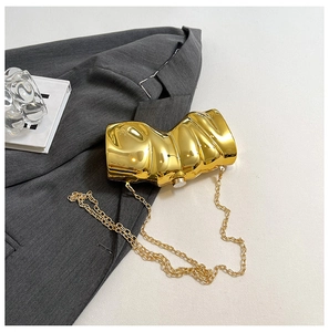 Detailansicht der goldenen Abendtasche mit unregelmäßiger Wellenstruktur und Goldkette