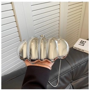 Close-up of silver wavy acrylic clutch bag with metallic finish and chain strap