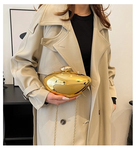 Detailed view of the mirror-finished golden pebble clutch with a metallic chain strap