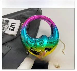 Close-up of iridescent crescent moon evening bag with star texture and gold chain strap