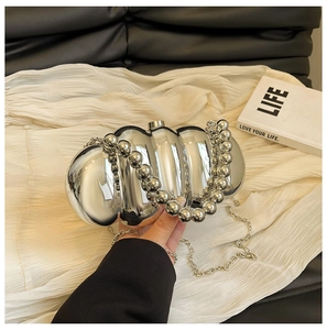 Detailed shot of silver textured acrylic clutch bag with metal ball handle and long chain