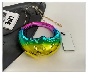 Mini crescent evening bag with iridescent finish and gold chain shown next to a smartphone