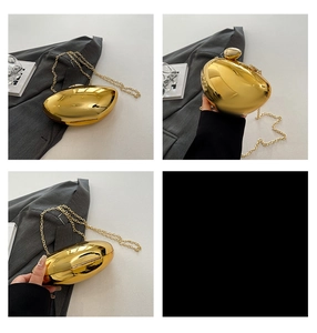 Close-up of gold egg-shaped clutch bag with polished mirror finish and chain strap