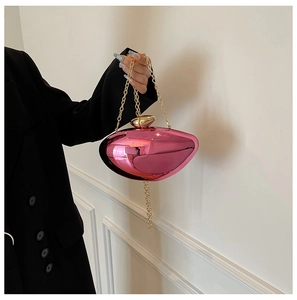 Detailed view of pink metallic lip-shaped evening clutch with gold chain and clasp